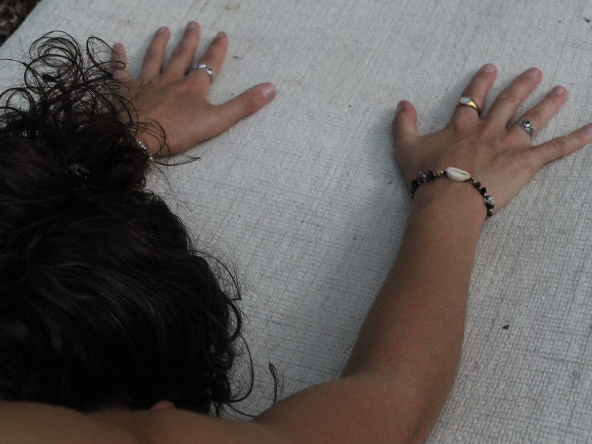 Hands pressed into a mat at the start of a HabiMat Pilates class in the woods